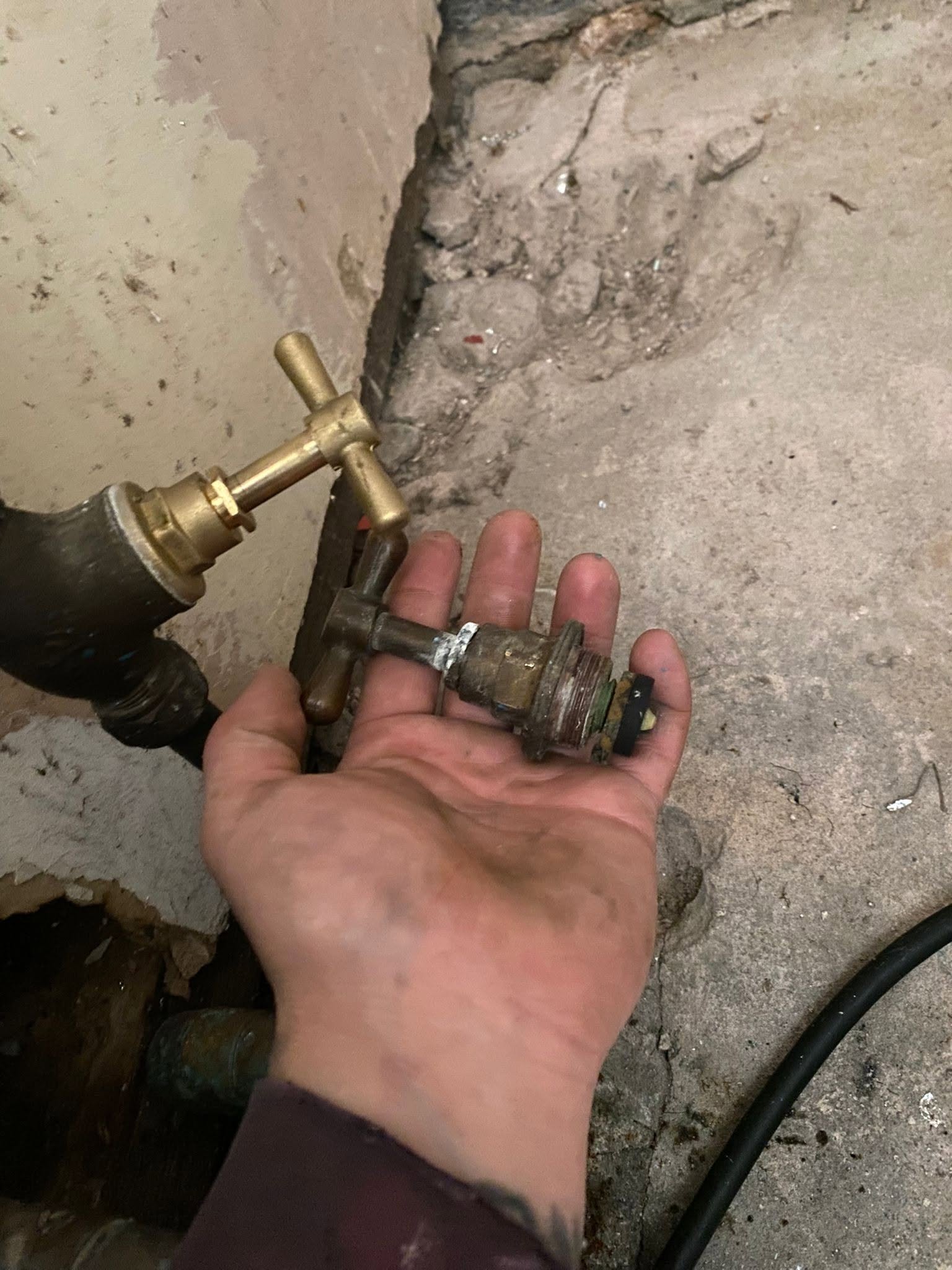 A worn brass valve held in a hand