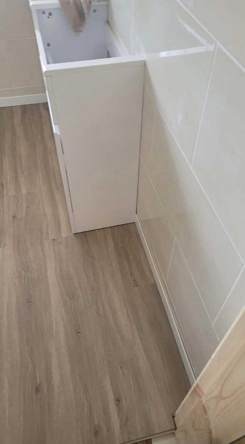 A vanity unit and wood-effect flooring in a finished bathroom