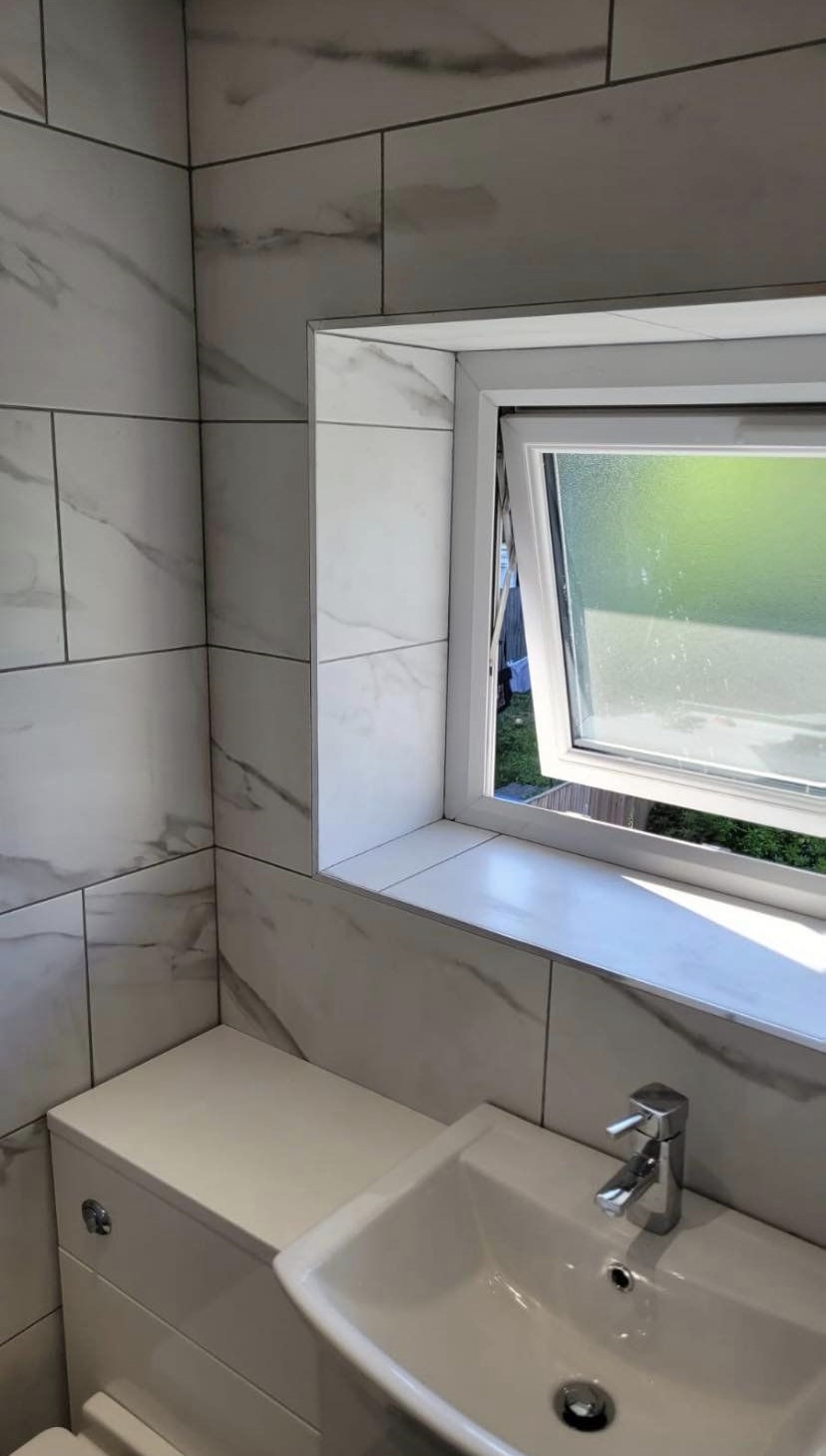 A vanity unit and basin with a tiled window sill