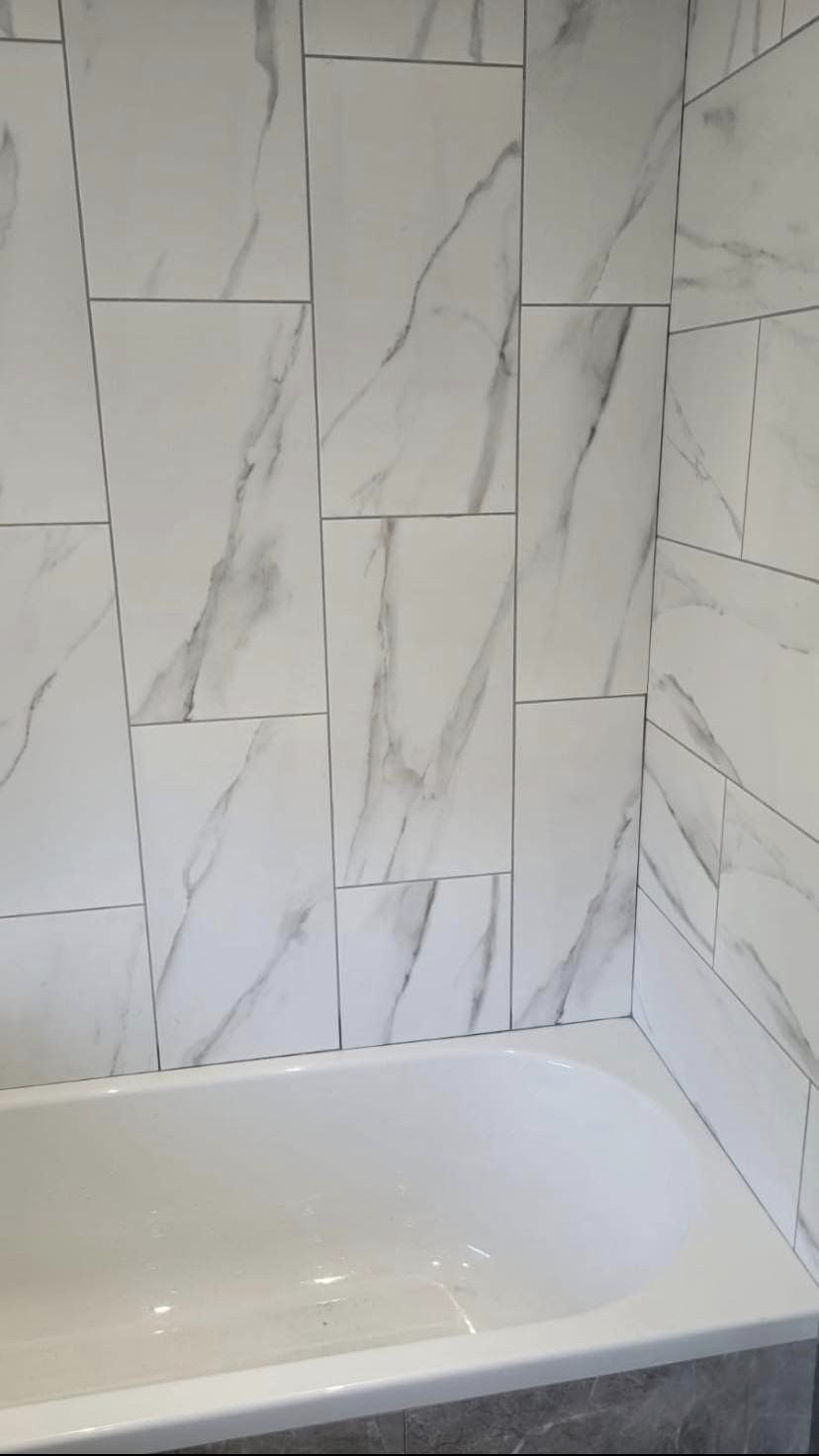 Large marble-effect wall tiles above the new bath